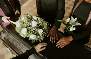 Mourners touching coffin at funeral